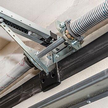 A broken torsion spring with a visible gap in the coil above a garage door