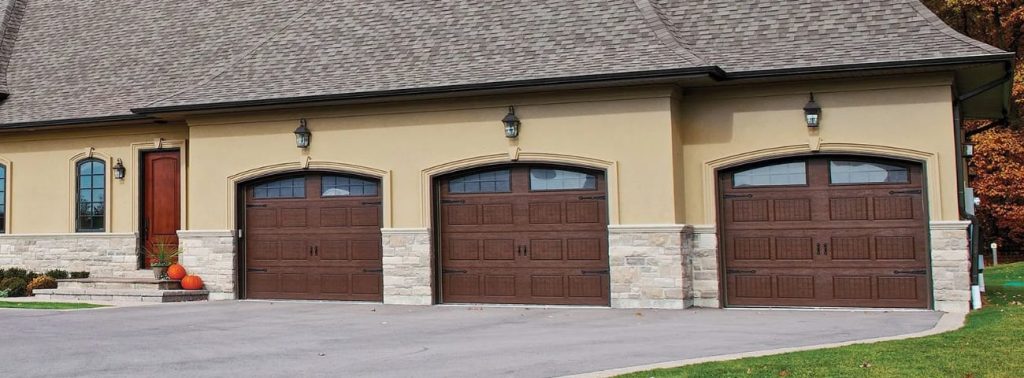 Garages with wood-tone carriage-style doors, arched windows.
