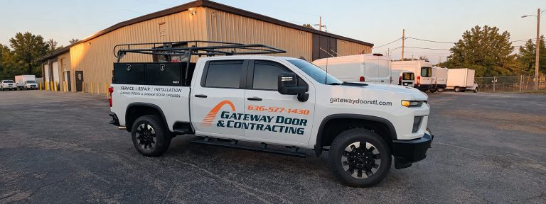 A branded Gateway Door and Contracting service truck parked outside the company warehouse