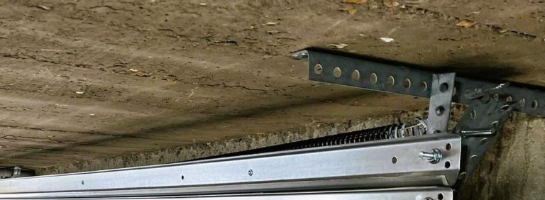 The horizontal rail and hanger bracket of a garage door track inside a St. Charles garage
